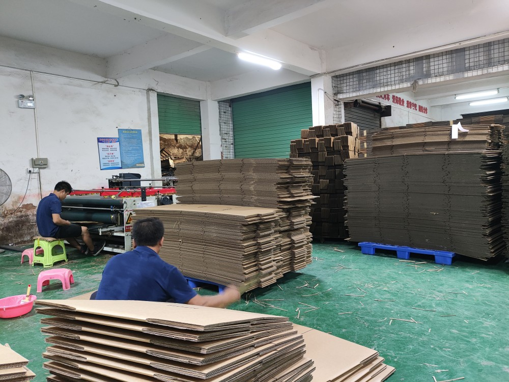 深圳市晨杰纸品工厂车间,工人正在处理瓦楞纸板